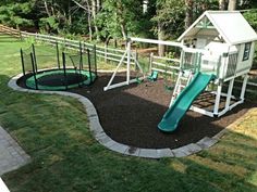 a play area with a slide, swing set and climbing frame in the back yard