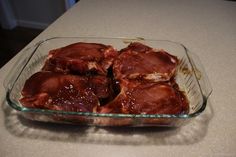 a glass dish filled with meat sitting on top of a counter