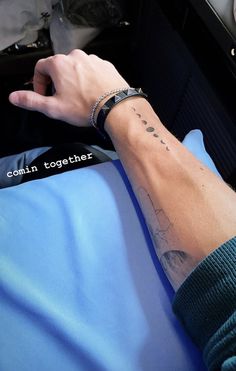 a person with a wrist tattoo on their left hand and the words, come together