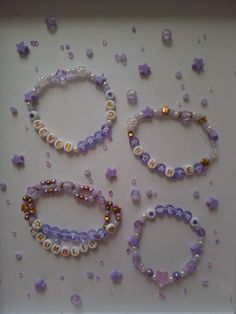 three bracelets with beads and pearls on a white surface next to other jewelry items