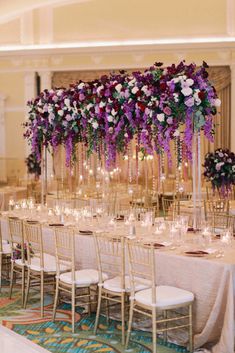 the tables are set up with tall centerpieces and floral arrangements on each table