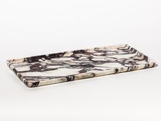 a white and black marbled serving tray on a white surface with no one around it