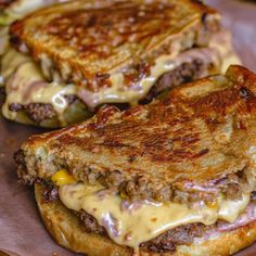 two grilled cheeseburgers sitting on top of a plate