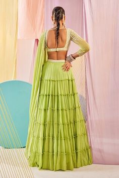 Lime green hand dyed padded blouse with full sleeves, vibrant resham, glass beads and rain-drop pearls lines hand embroidery. Paired with a voluminous attached cancan multi-tiered lehenga with resham, glass beads, rain-drop pearls embroidered waist belt and a chiffon dupatta with densely scattered white bead florets and rain-drop leaf border. - Aza Fashions Green Long Sleeve Choli For Wedding, Fitted Green Bohemian Lehenga, Green Fitted Bohemian Lehenga, Fitted Bohemian Green Lehenga, Blouse With Full Sleeves, Tiered Lehenga, Raw Silk Embroidery, Padded Blouse, Leaf Border