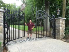 a man standing in front of an iron gate