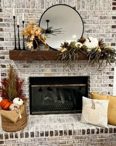 a brick fireplace decorated for fall with pumpkins and greenery