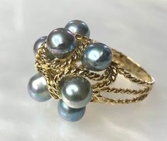 Pearl Ring, Gray Pearl Ring, Vintage Ring, Gray Pearl, Statement Ring , Grey Pearl, Vintage Pearl Ring, Grey Pearl Ring, Pearl Jewelry An eye catching and stylish ring featuring 8 grey pearls wrapped in braided/ twisted 14k gold. Ring size: US 7 Fine Jewelry Yellow Gold Pearl Ring With High Luster, Yellow Gold Pearl Ring With High Luster, Vintage Multi-stone Pearl Ring For Anniversary, Vintage Multi-stone Pearl Ring For Formal Occasions, Vintage Multi-stone Pearl Ring For Formal Events, Timeless High Luster Rings As A Gift, Timeless High Luster Rings For Gift, Heirloom Yellow Gold Pearl Ring, Timeless High Luster Rings As Gifts