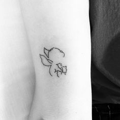 a black and white photo of a small flower tattoo on the left inner arm,