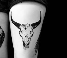 two black and white tattoos on the legs of people with long horns, one has a skull