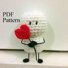 a crocheted doll holding a red heart on top of a white shelf with the words pdf pattern above it