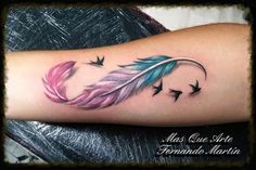 a colorful feather with birds flying around it on the arm and wrist tattoo design for women