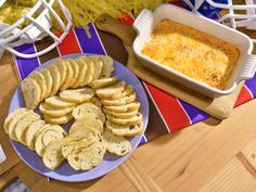 a plate with crackers on it next to a bowl of macaroni and cheese