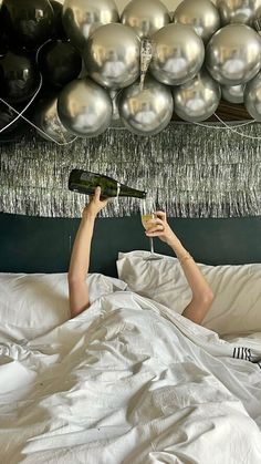 a man laying in bed with two champagne flutes