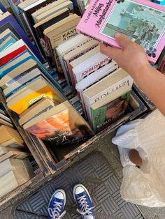 a person is standing in front of a box full of books