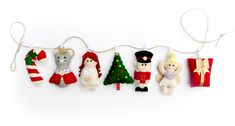 several stuffed animals hanging on a string with christmas decorations attached to the strings, all decorated in different colors and sizes