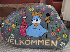 a painted rock with an image of a bird and a crown on it that says velkommen