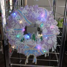 a lighted wreath hanging from a wire rack in a room with other items on the shelves