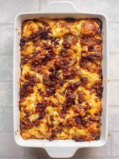 a casserole dish with meat and cheese in it on a white table top