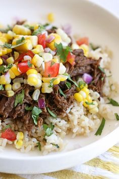 a white plate topped with rice and corn