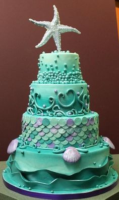 a three tiered cake with a starfish on top