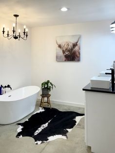 a bath room with a tub and a cow rug