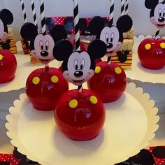 there are many mickey mouse cake pops on the table with candles in the shape of apples