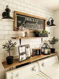 a washer and dryer in a room with white tiles on the walls, shelves above them