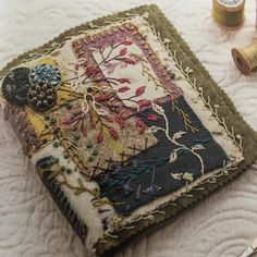 a close up of a piece of cloth on a table with thread and sewing supplies