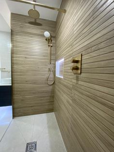 the shower head is mounted to the wall in this modern bathroom with wood paneling