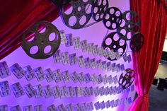 some film reels are hanging on the wall next to a red drapes and curtains