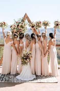 the bridesmaids are holding their bouquets high in the air and posing for a photo