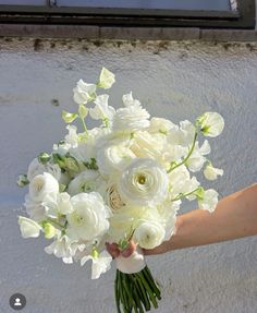 a person holding a bouquet of white flowers