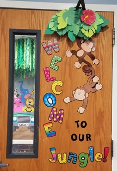 a door decorated with the words welcome to our jungle and monkeys hanging from it's side