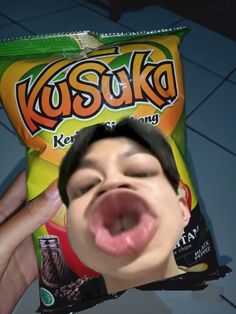 a person sticking their tongue out in front of a bag of kosuka chips