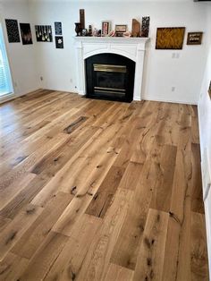 an empty living room with wood floors and a fireplace