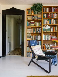 a chair sitting in front of a book shelf filled with books