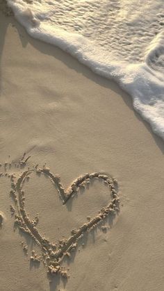 a heart drawn in the sand at the beach