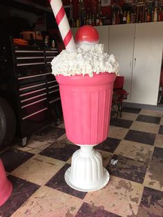 a pink ice cream sundae sitting on top of a checkered floor