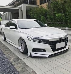 two white cars parked next to each other in front of a building