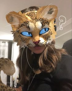 a woman wearing a cat mask with blue eyes and leopard print on her face,