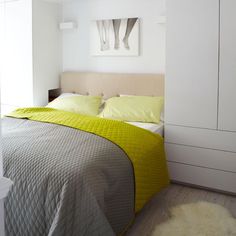 a bedroom with white walls and yellow bedding