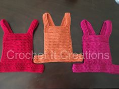 three crocheted bags sitting next to each other on top of a black table