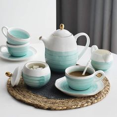 tea set with cups and saucers sitting on a place mat