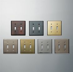 five different types of light switch plates are arranged in a row on a silver wall