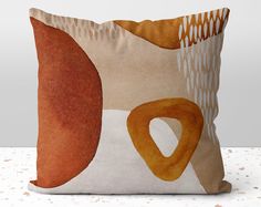 an orange and white pillow sitting on top of a table