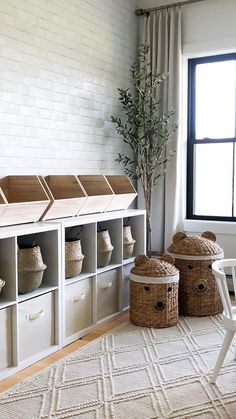 a living room filled with lots of storage and furniture next to a window on top of a white rug