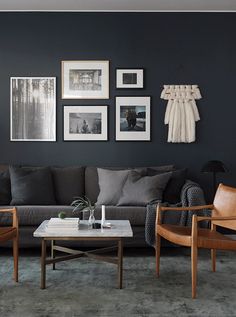 a living room filled with furniture and pictures hanging on the wall above it's coffee table