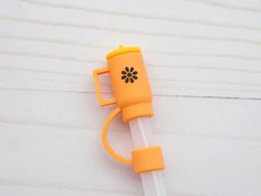 an orange and white plastic object with a flower on it