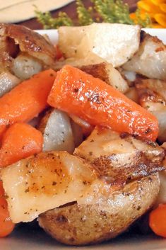 a white plate topped with chicken, carrots and potatoes