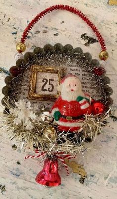 a christmas ornament with a santa clause sitting on top of tinsel covered branches